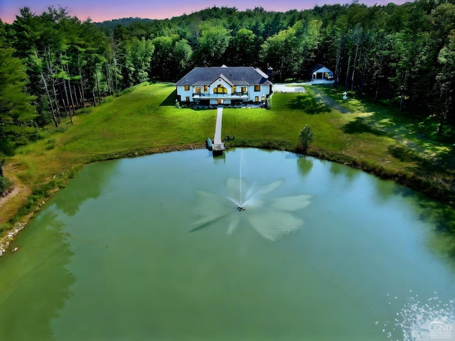 aerial view at dusk featuring a water view