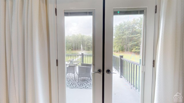 doorway to outside with french doors, a water view, and a healthy amount of sunlight