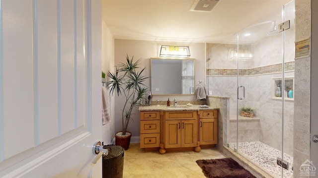 bathroom with vanity and a shower with door