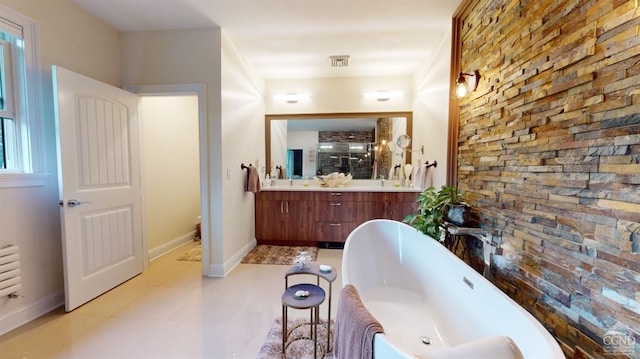 bathroom featuring tile patterned flooring, vanity, and a bath