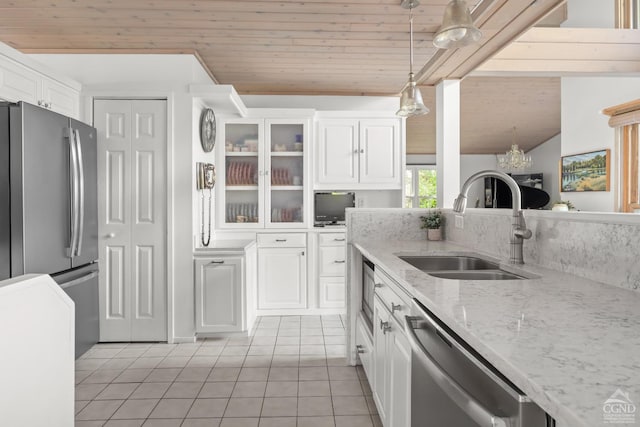 kitchen with white cabinets, sink, light tile patterned floors, appliances with stainless steel finishes, and decorative light fixtures