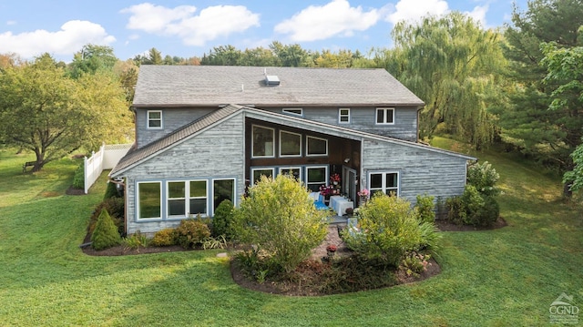 rear view of house featuring a yard