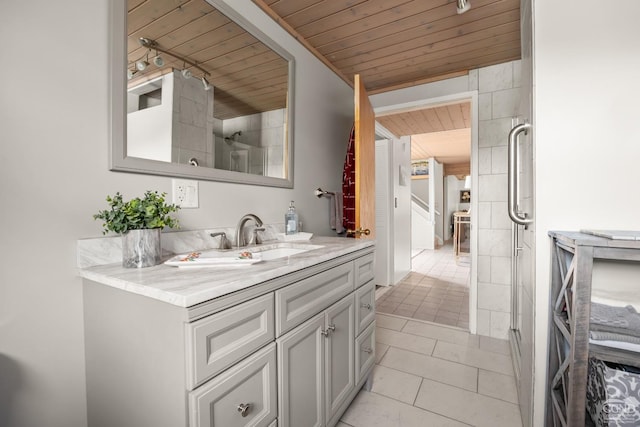 bathroom featuring tile patterned flooring, vanity, and wooden ceiling