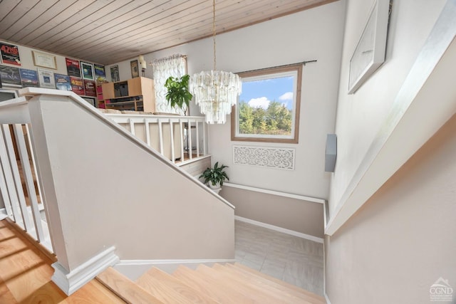 staircase featuring an inviting chandelier and wood ceiling