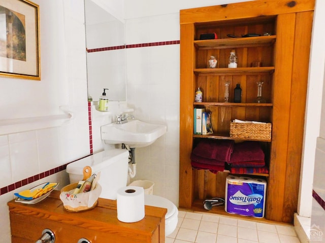 bathroom with tile patterned floors, toilet, and tile walls