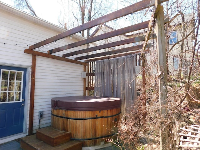 wooden deck featuring a pergola and a hot tub