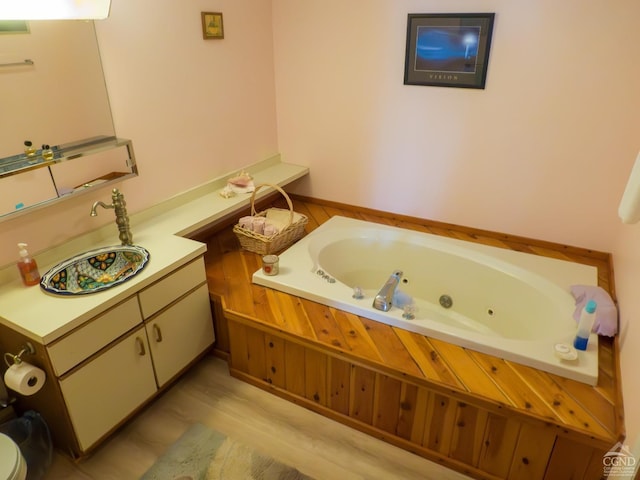 bathroom with a tub to relax in and hardwood / wood-style flooring