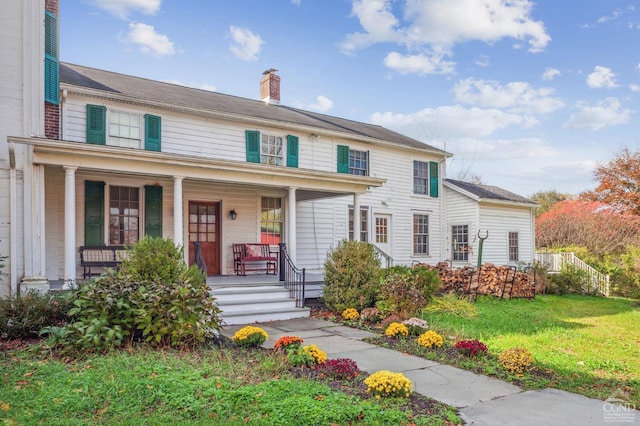 view of front of home featuring covered porch and a front yard