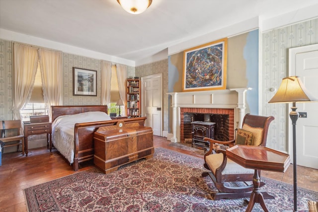 bedroom with dark hardwood / wood-style flooring and a wood stove