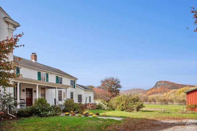 view of front of home with covered porch and a mountain view