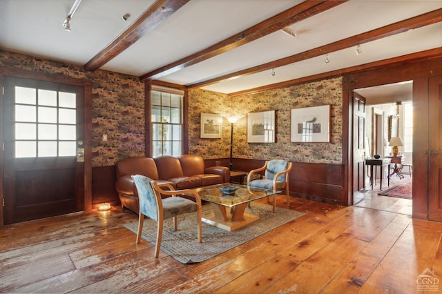 living room featuring beamed ceiling and light hardwood / wood-style floors