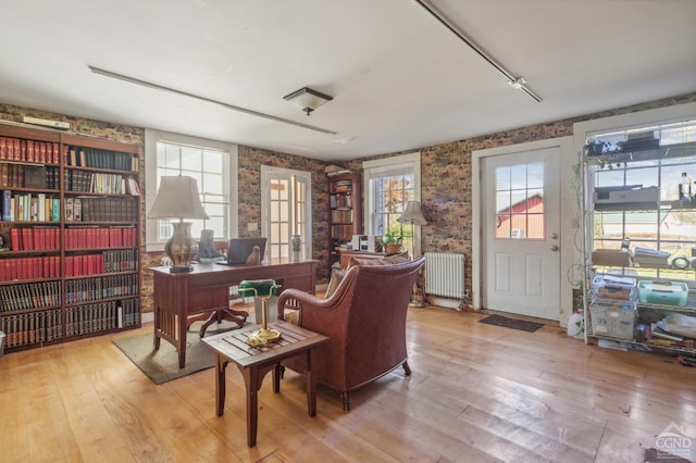 living area featuring radiator heating unit and light hardwood / wood-style flooring