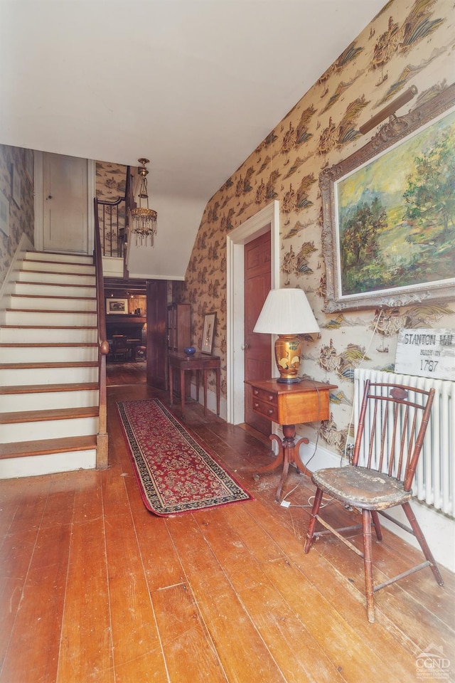 interior space featuring hardwood / wood-style flooring, radiator, and vaulted ceiling