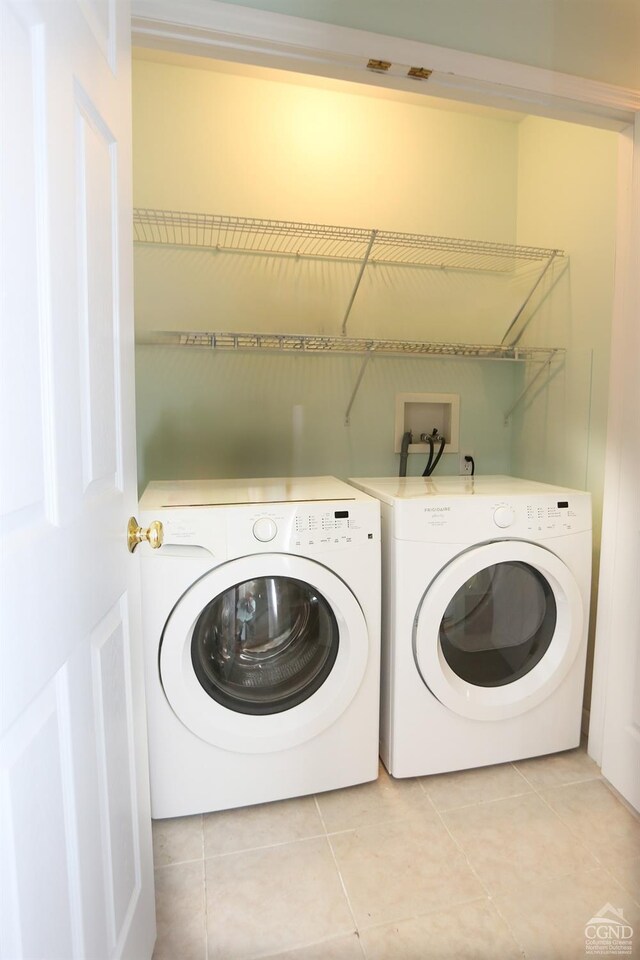 laundry room with laundry area, light tile patterned flooring, and separate washer and dryer