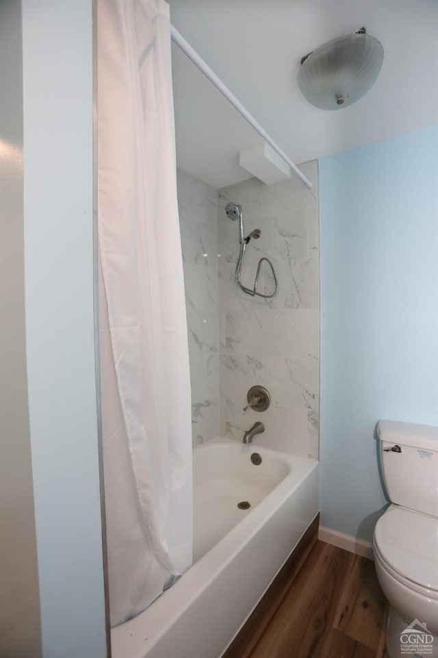 full bath featuring toilet, wood finished floors, shower / bath combo with shower curtain, and baseboards