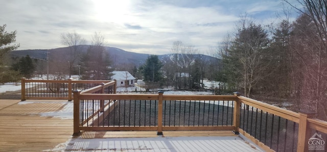 snow covered deck with a mountain view