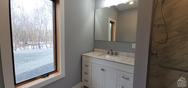 bathroom with a tile shower and vanity