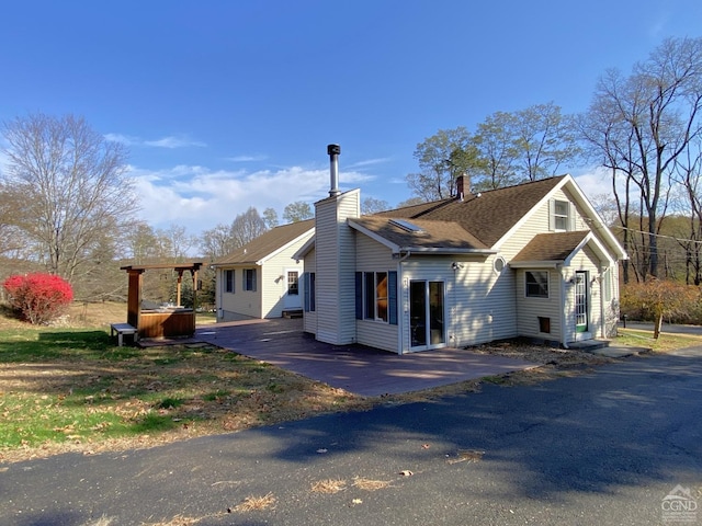 view of home's exterior featuring a jacuzzi and a patio