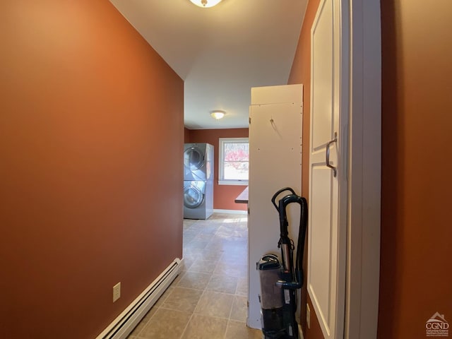 hall with stacked washer and dryer and a baseboard heating unit