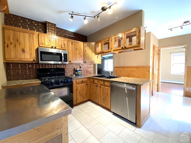 kitchen featuring sink, stainless steel appliances, baseboard heating, backsplash, and kitchen peninsula