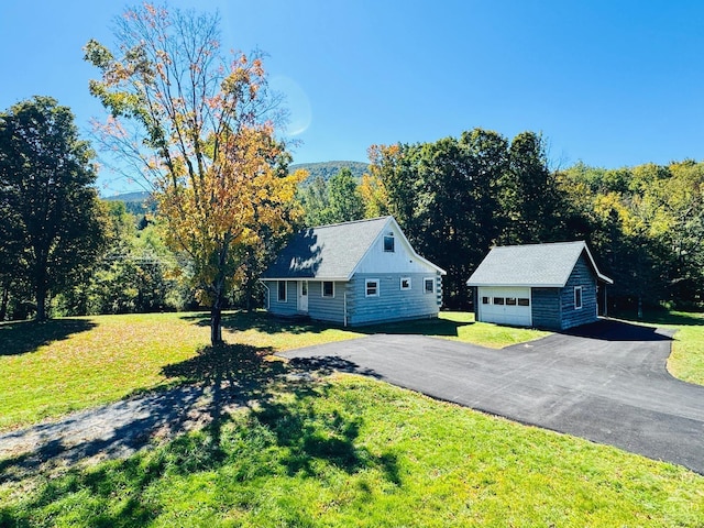 view of front facade featuring an outbuilding, a garage, and a front lawn