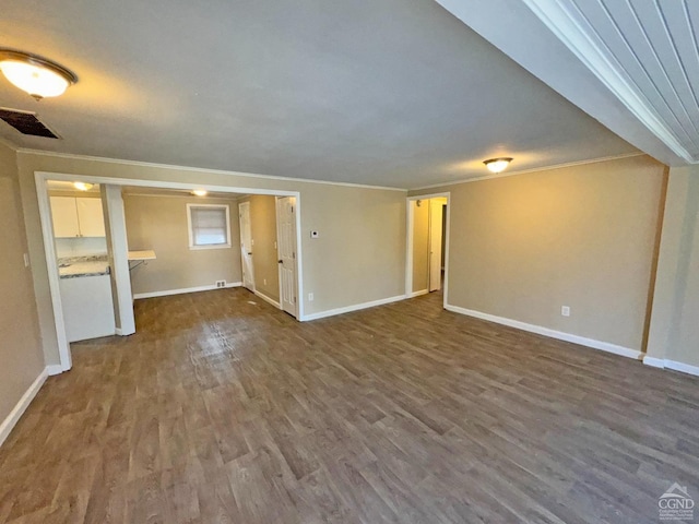 unfurnished living room with wood-type flooring and crown molding