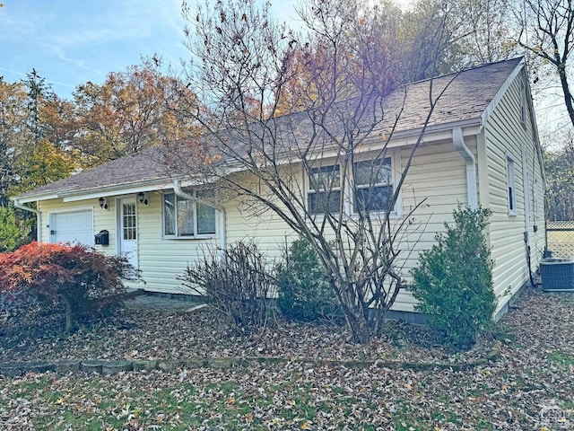 single story home with a garage and central air condition unit