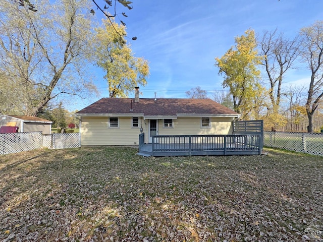 rear view of house featuring a lawn and a deck