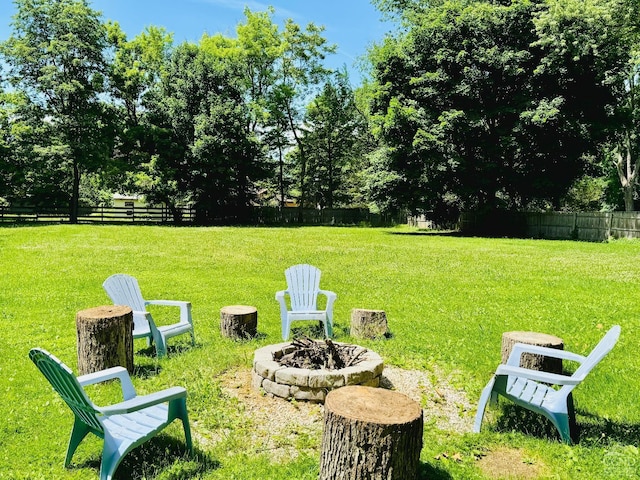 view of yard with a fire pit and fence