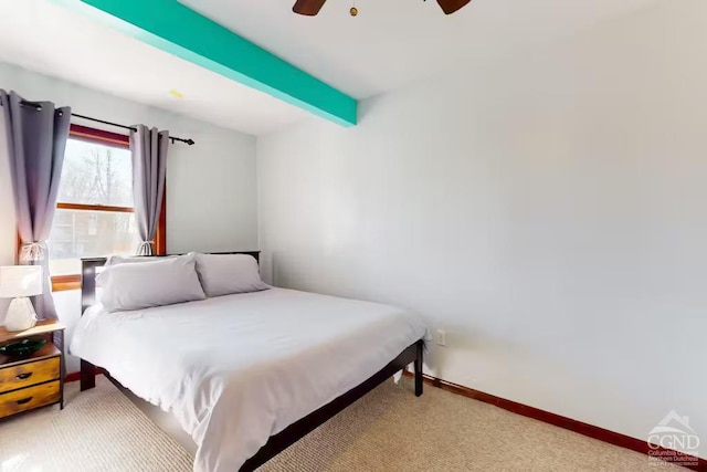 carpeted bedroom with baseboards, beam ceiling, and ceiling fan