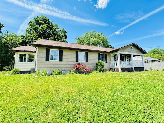 ranch-style home with a front lawn and fence