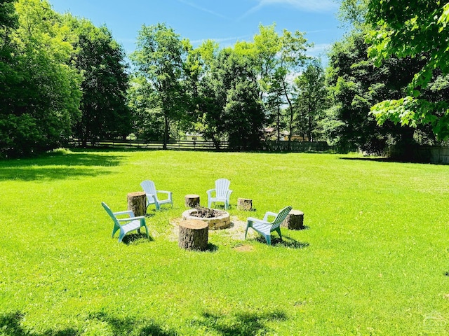 view of yard with an outdoor fire pit and fence