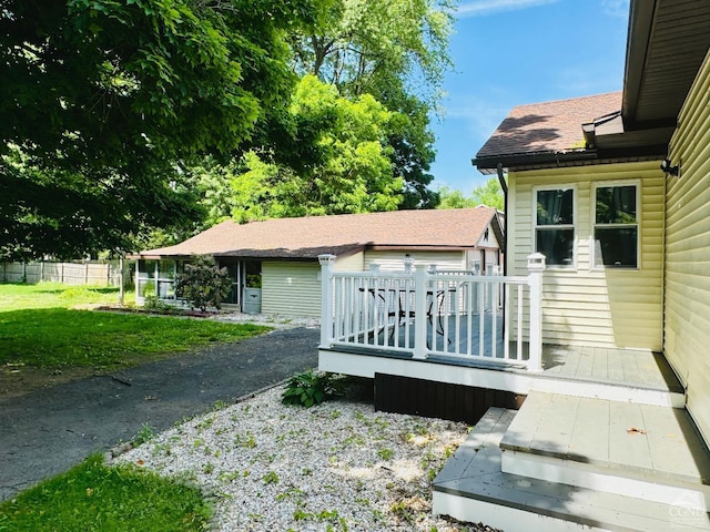 exterior space featuring a wooden deck and roof with shingles