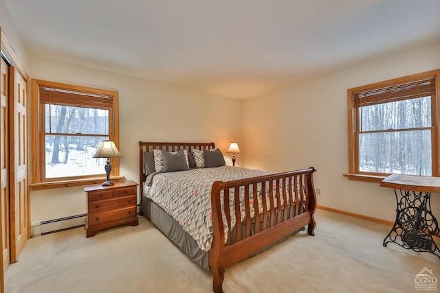 bedroom featuring a baseboard heating unit and light colored carpet