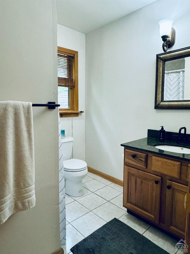 bathroom with toilet, vanity, and tile patterned floors