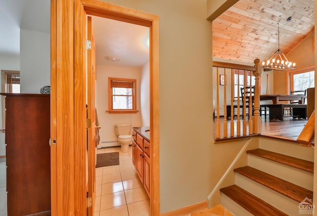 stairway featuring an inviting chandelier, wooden ceiling, baseboard heating, lofted ceiling, and tile patterned floors