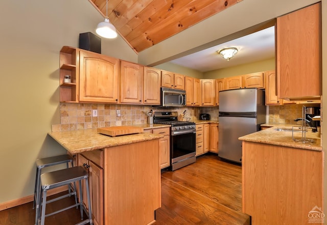 kitchen featuring stainless steel appliances, light brown cabinetry, light hardwood / wood-style floors, sink, and kitchen peninsula