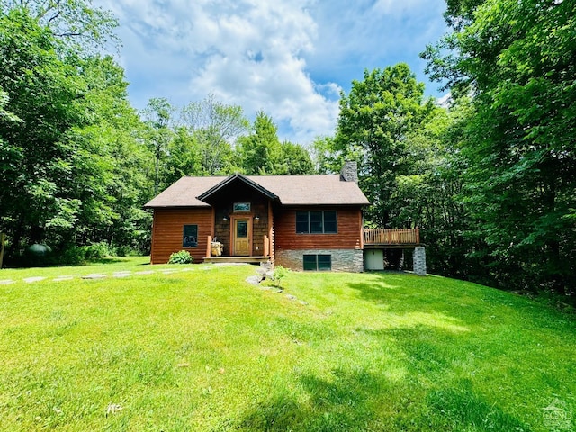 log cabin with a deck and a front lawn