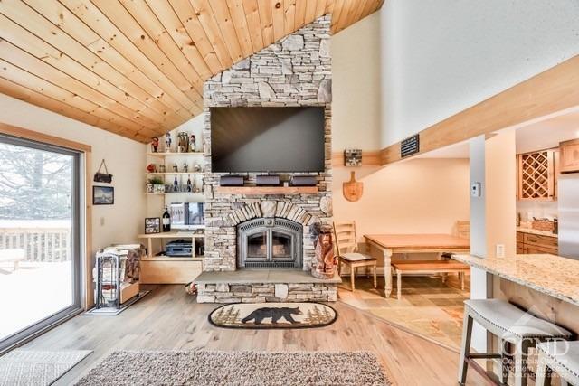 living room featuring a fireplace, high vaulted ceiling, wood ceiling, and light wood-type flooring