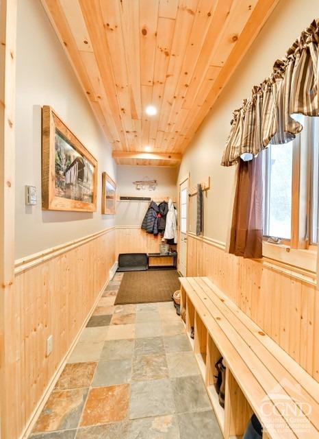 mudroom featuring wood walls and wood ceiling