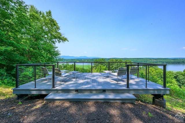 wooden terrace featuring a water and mountain view