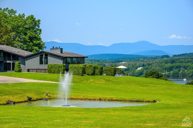 view of community featuring a yard and a water and mountain view