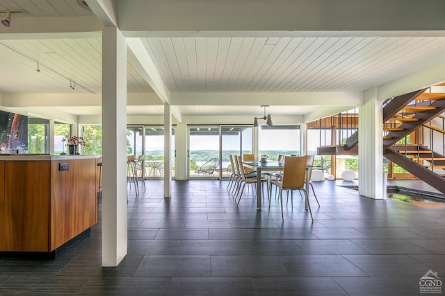 sunroom featuring beam ceiling and track lighting