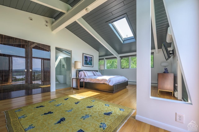 bedroom featuring a baseboard heating unit, light wood finished floors, lofted ceiling with skylight, and baseboard heating