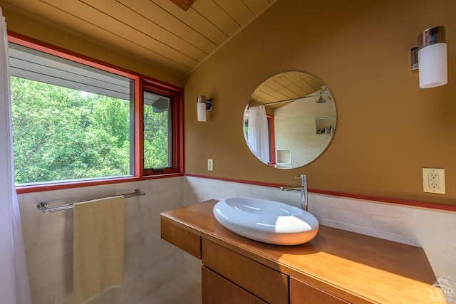 bathroom with tile walls, wood ceiling, wainscoting, vaulted ceiling, and vanity