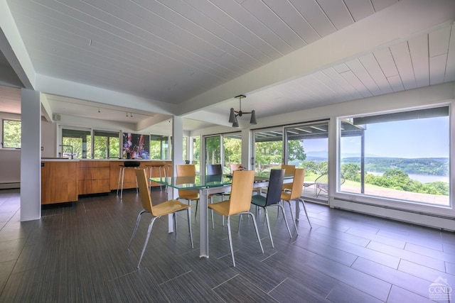 dining space with a baseboard radiator, dark wood-style flooring, and beamed ceiling