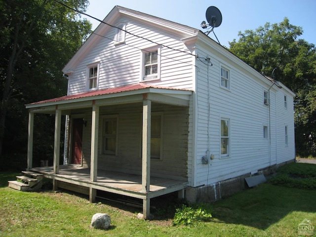 rear view of house with a yard and covered porch