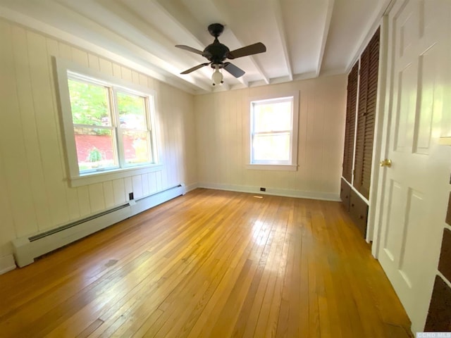 unfurnished bedroom featuring ceiling fan, light hardwood / wood-style floors, baseboard heating, and multiple windows