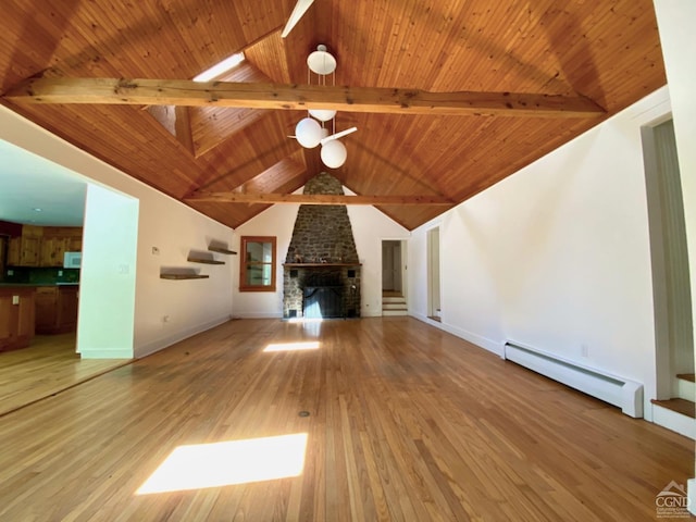 unfurnished living room with baseboard heating, a stone fireplace, lofted ceiling with beams, wood-type flooring, and wood ceiling