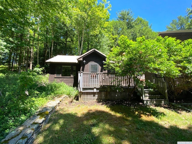 exterior space with a front lawn and a wooden deck